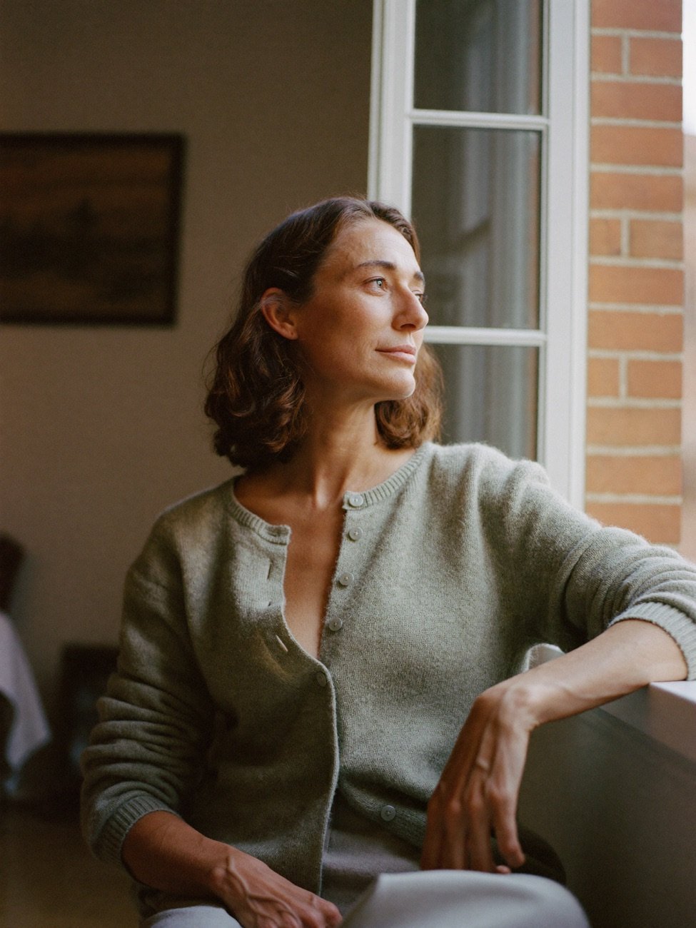 mujer adulta serena en un piso de Madrid, luz natural, digna
