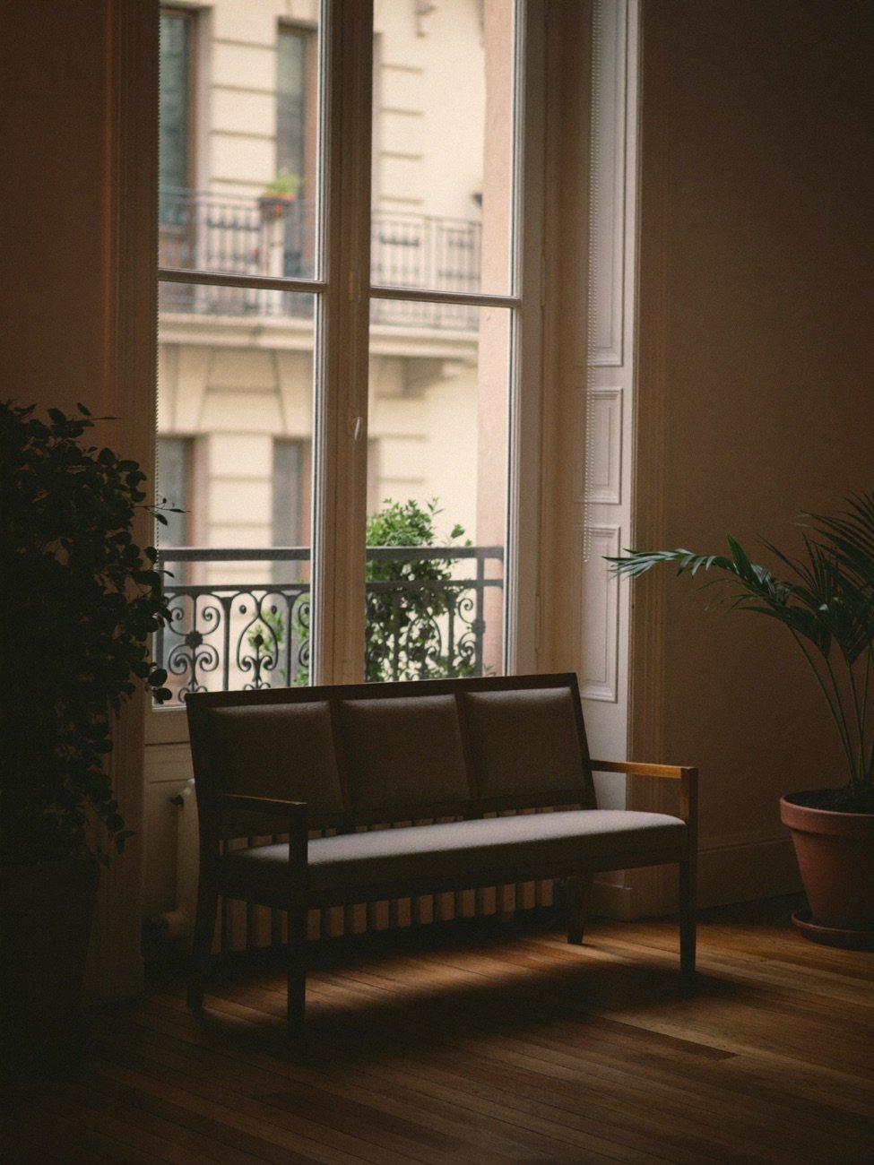 Consulta de psicología vacía en Chamberí, Madrid: dos sillones enfrentados, mesa baja con una planta, estantería con libros y luz de tarde por la ventana; sin personas
